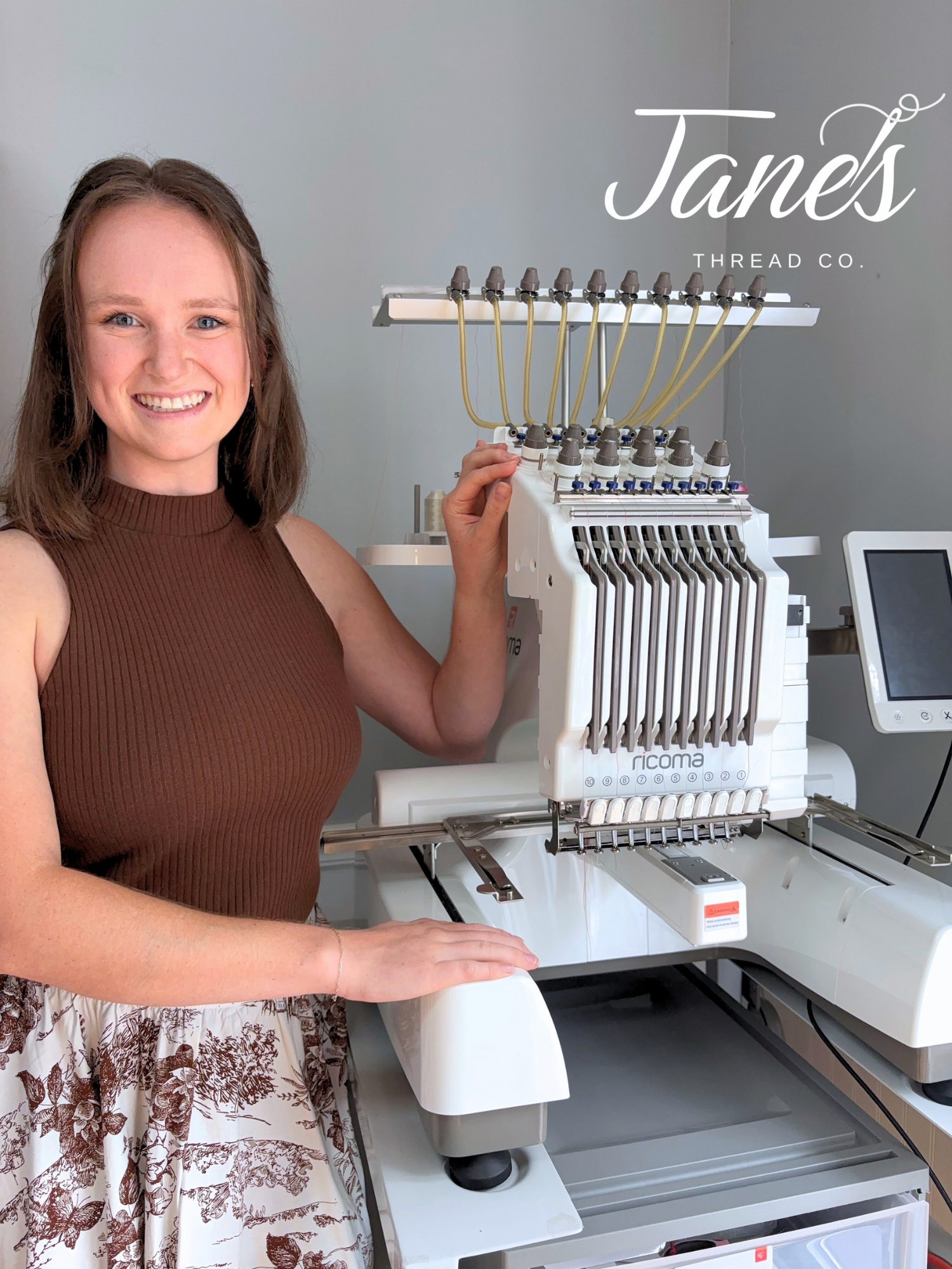Woman standing next to an embroidery machine with 'Janes Thread Co.' branding.