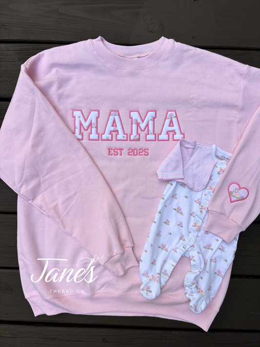MAMA on a pink sweatshirt with a heart on the sleeve